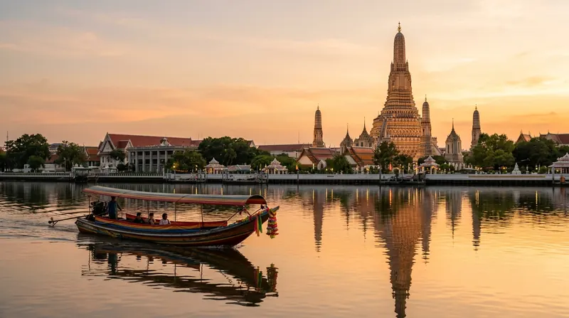 Tempel mit hohem Turm am Fluss in Bangkok bei Sonnenuntergang, davor ein Holzboot